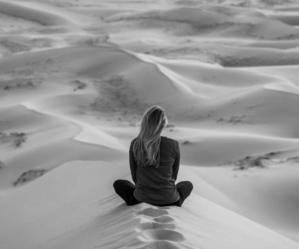 Woman sitting in the middle of the desert