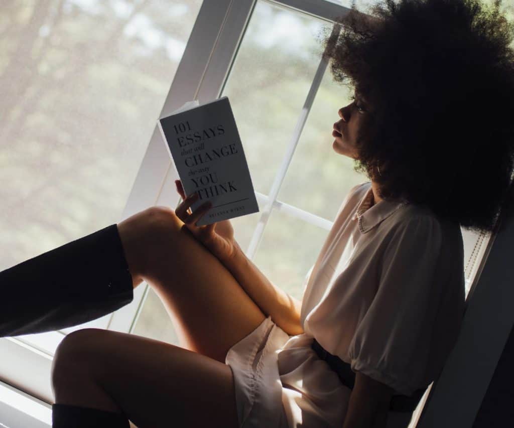 Woman reading a book near the window